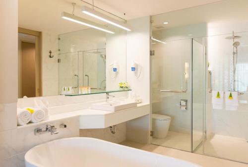 a bathroom with a tub and a sink and a shower at Katathani Phuket Beach Resort - SHA Extra Plus in Kata Beach