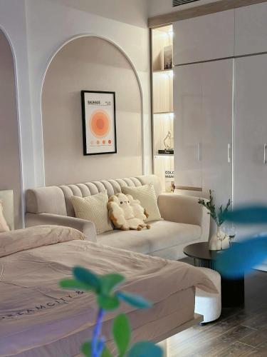 a living room with a bed and a couch at Lumi Homestay in Phú Thú