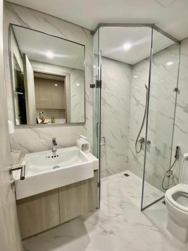 a bathroom with a sink and a shower and a toilet at Lumi Homestay in Phú Thú