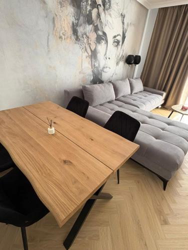 a living room with a wooden table and a couch at Apartament nad jeziorem Rosnowo in Rosnowo