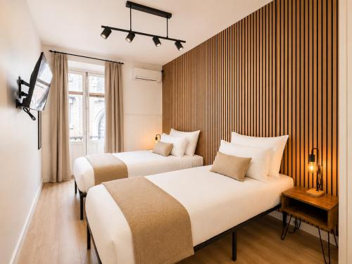 a hotel room with two beds and a tv at Casa Antares Granada in Granada
