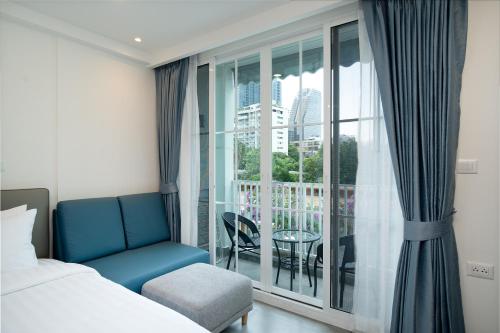 a bedroom with a bed and a large window with a balcony at Mac's House in Bangkok