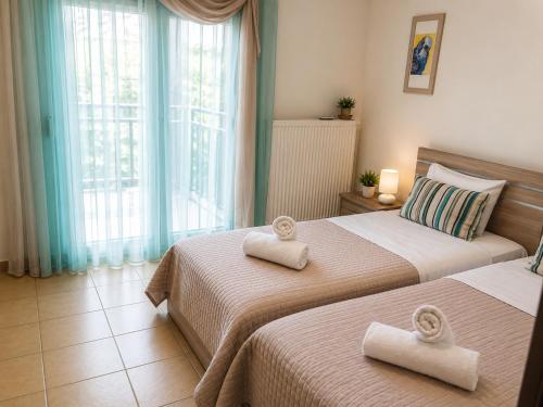 two beds in a bedroom with towels on them at Angel Luxury Apartments in Keramoti