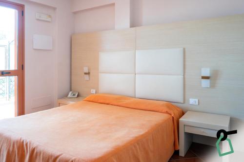 a bedroom with a large bed with an orange blanket at Hotiday Taormina Mazzeo in Taormina