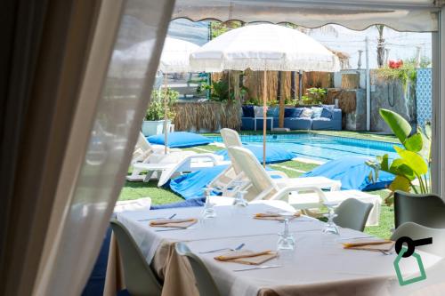 a table set up for a wedding with a pool in the background at Hotiday Taormina Mazzeo in Taormina