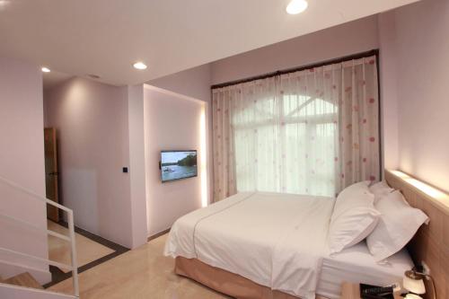 a bedroom with a white bed and a window at Gancheng 35 in Jian