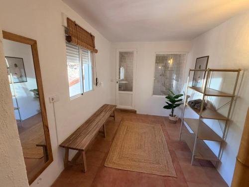 a room with a wooden bench and a shelf at Enamórate con vistas al mar en La Marina House in La Alcazaba