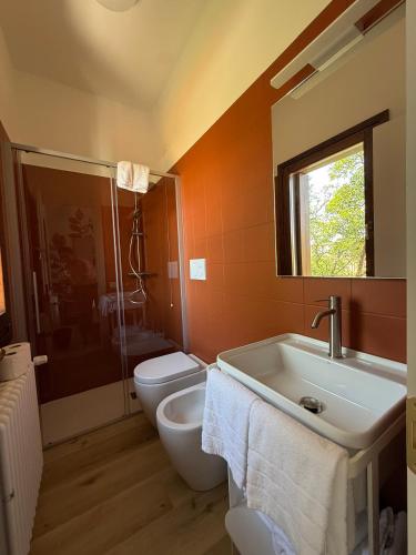 a bathroom with a toilet and a sink and a mirror at LEON D'ORO - Art Hotel in Pieve di Soligo