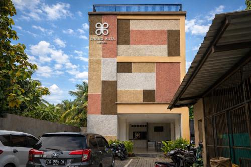 a building with a sign on the side of it at Grand Kuta Hotel Lombok - Pool - 43 inch Google TV - Strong 60Mbps WiFi - New Enhanced Management in Kuta Lombok