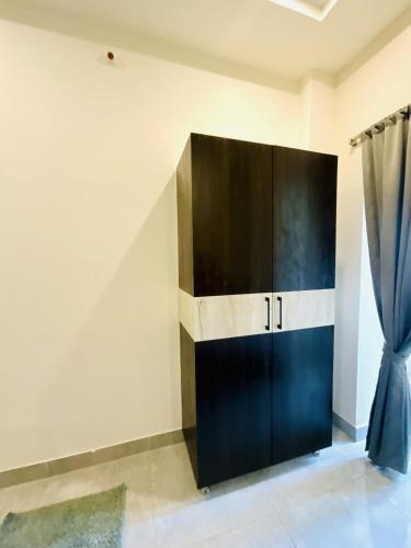a black cabinet in a room with a curtain at MGR RESIDENCY in Srikalahasti