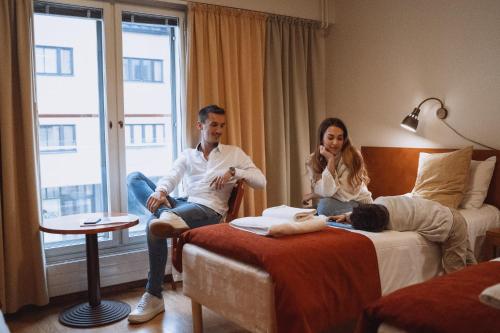 a man and a woman sitting in a hotel room at Hotelli Helmi in Turku