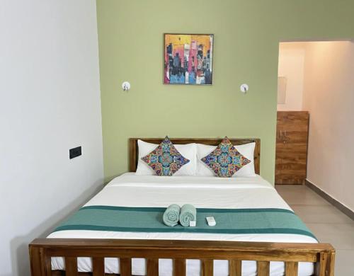 a bedroom with a bed with two slippers on it at The Haira Varkala in Varkala