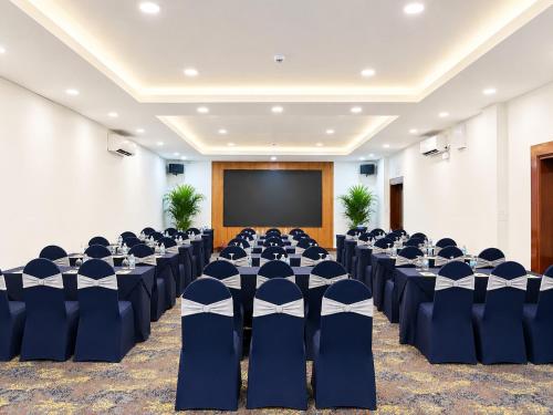 a conference room with blue chairs and a screen at Oscar Saigon Hotel in Ho Chi Minh City