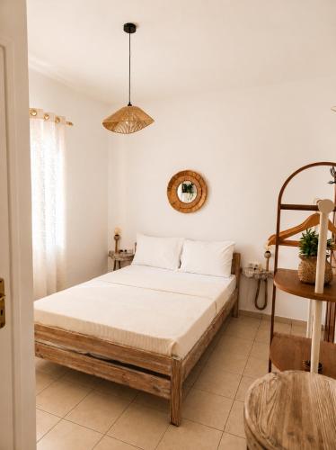 a bedroom with a large bed with white sheets at Sunset studio in Plaka in Plaka Milou