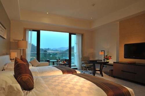 Katil atau katil-katil dalam bilik di Mels Weldon Evergreen Lake Hotel Heyuan
