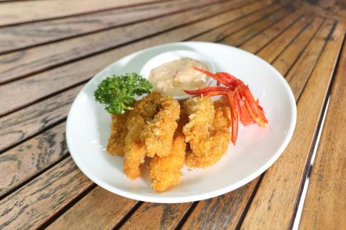 a plate of food with shrimp and mashed potatoes and broccoli at The Grand Palace Hotel Yogyakarta in Yogyakarta