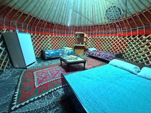 a room with a yurt with a tv and a table at Guest House Oimo in Balykchy