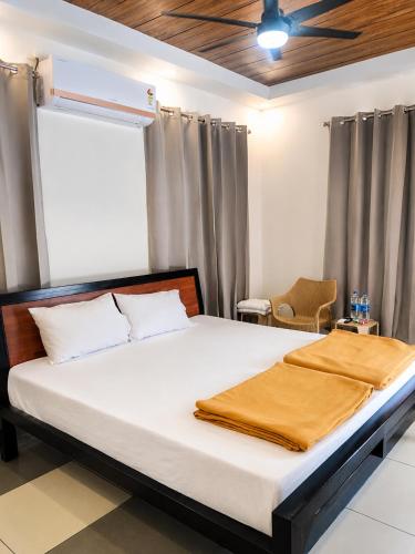 a bedroom with a bed with white sheets and a ceiling at SRK luxe resort in Maivādi Road