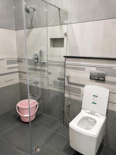 a bathroom with a toilet and a glass shower at SRK luxe resort in Maivādi Road