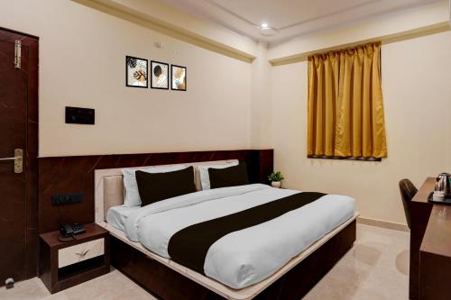 a bedroom with a large bed and a window at Super Collection O Zero Mile Patna Formerly Chandrashila Residency in Gulzārbāgh