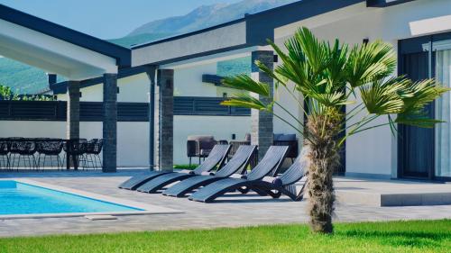a group of lounge chairs next to a swimming pool at Luxury Villa Domino with Heated Pool in Mostar