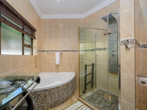 a bathroom with a tub and a glass shower at Seagull Villa in Margate