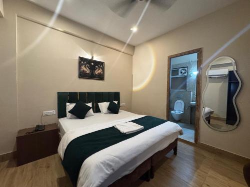 a bedroom with a large bed and a mirror at Hotel Green Land in Mathura