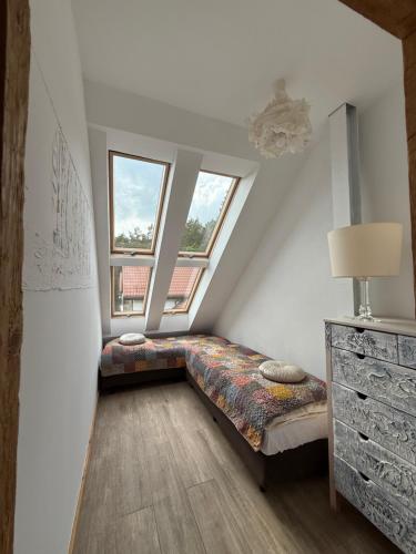 a bed in a room with two windows at Apartament Art & Lake View in Gryzliny