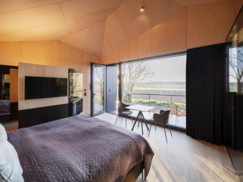 a bedroom with a large bed and a large window at Kapolcsi Sziklák in Vigántpetend