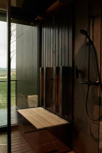 a bathroom with a shower with a bench in it at Kapolcsi Sziklák in Vigántpetend