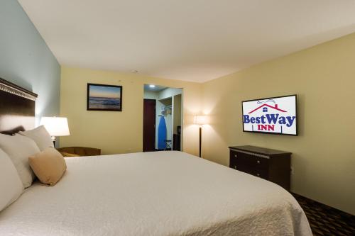 a hotel room with a television and a bed at Best Way Inn Cleburne in Cleburne