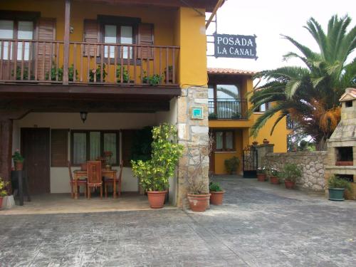 a building with a balcony and a table and chairs at La Canal in Ubiarco