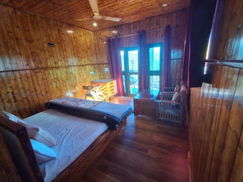 ein Schlafzimmer mit einem Bett in einer Holzwand in der Unterkunft Lal Bangla Homestay in Chaukori