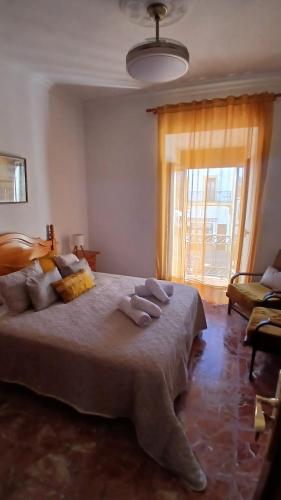 a bedroom with a large bed with a large window at El Molinero in Monesterio