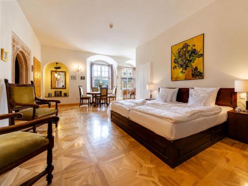a large bedroom with a bed and a chair at Schloss Purschenstein in Neuhausen