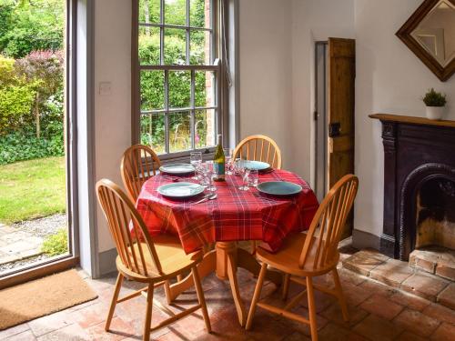 a dining room with a table and chairs and a fireplace at Mark's Cottage in North Walsham