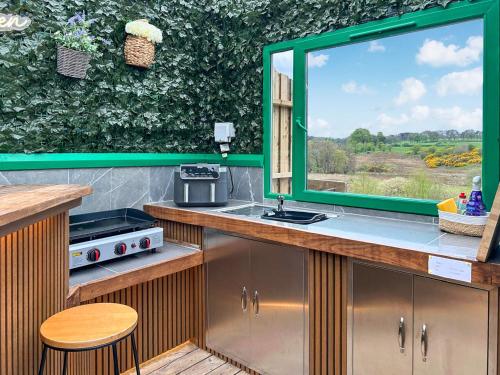 a kitchen with a window with a view of a field at Vessel 1 - Ukc9441 in Glasgow