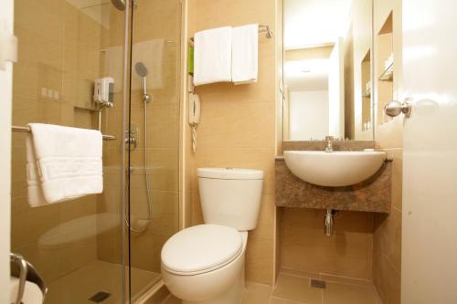 a bathroom with a toilet and a sink and a shower at St Giles Hotel Makati in Manila