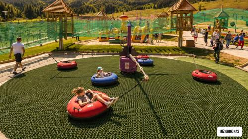 a group of people riding on tubes at an amusement park at DWOREK MYŚLIWSKI HUBERT- przy samych Termach Bania i Stoku Narciarskiego Kotelnica, na miejscu wypożyczalnia nart, rowerów elektrycznych w atrakcyjnej cenie dla gości in Białka Tatrzańska