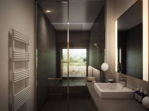 a bathroom with a tub and a sink and a shower at らうす餐荘 in Rausu