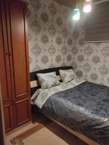a bedroom with a bed and a wooden cabinet at Beach House Buzovna in Baku