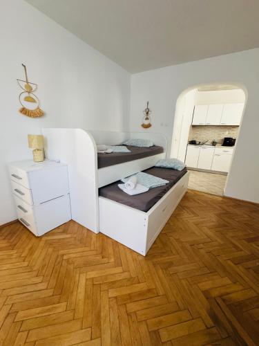 a bedroom with two bunk beds and a wooden floor at Apartmani Luciano in Novalja