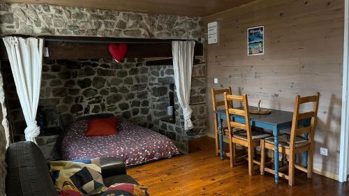 a bedroom with a bed and a table with a tableablish at Votre cocon en Ardèche Verte in Saint-Prix