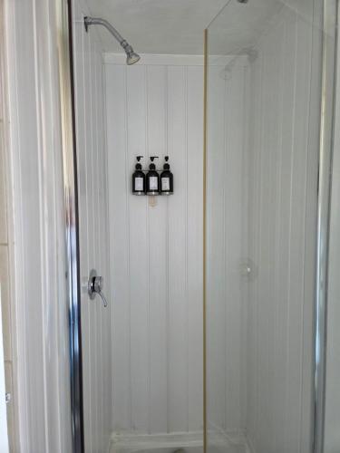 a bathroom with a shower with three bottles on a shelf at Glendor Hotel in Blackpool