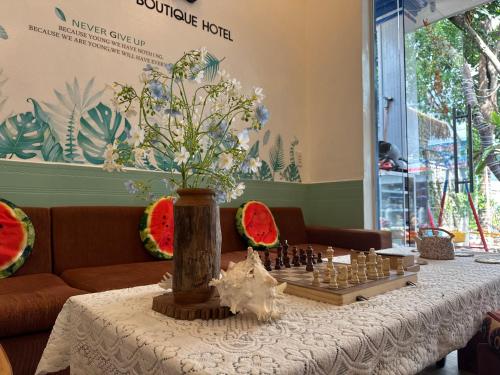 a table with a chess board and a vase with flowers at Côn Đảo Home in Con Dao