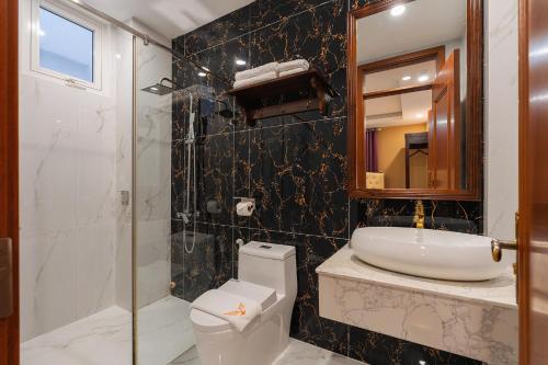 a bathroom with a toilet and a sink and a shower at Peach Valley Hotel Dalat in Da Lat