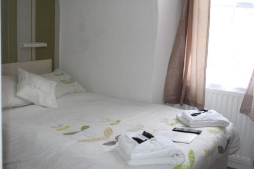 a bed with towels and remote controls on it at The Redcliff in Weymouth