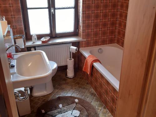 a bathroom with a sink and a tub and a toilet at Ferienwohnung Mutzenbauer in Bad Endorf