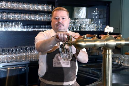 a man is preparing a drink in a bar at Grandhotel Ambassador Národní Dům in Karlovy Vary