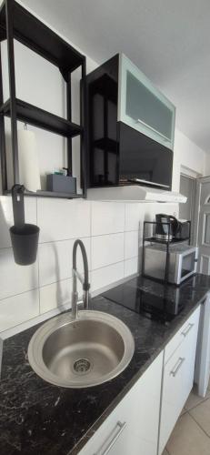 a kitchen counter with a sink and a microwave at Apartments Valentina Tisno in Tisno